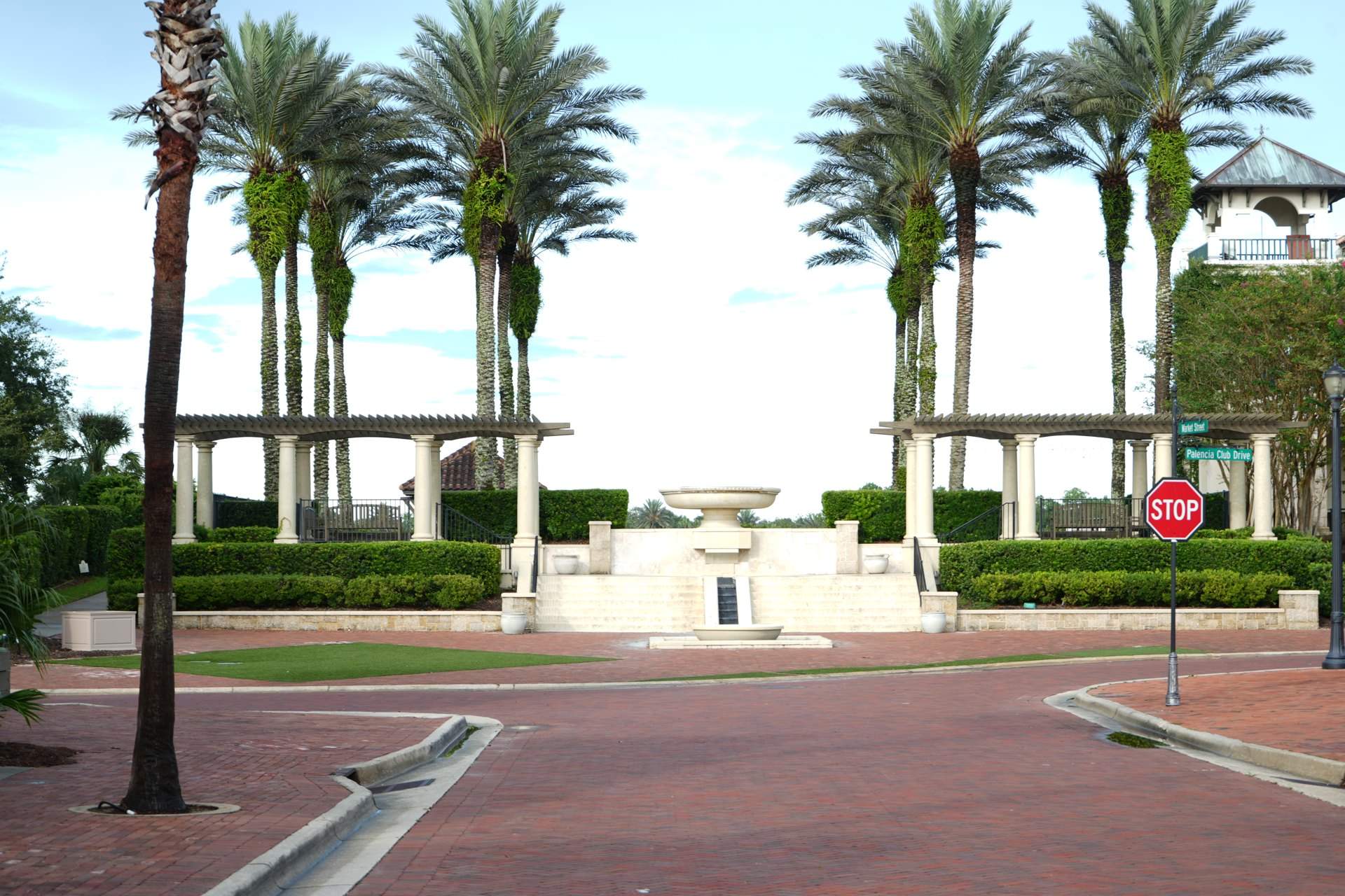 Fountain plaza framed by pergolas and palms in the Palencia village center