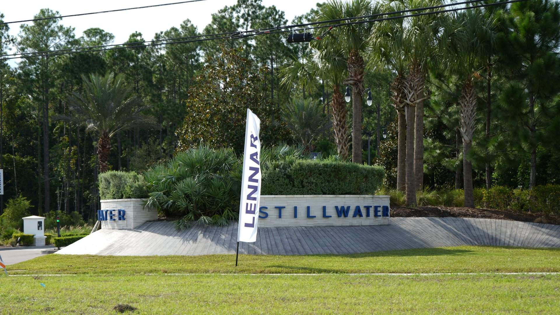 Stillwater community entrance sign with palms and a Lennar banner in St. Johns, Florida